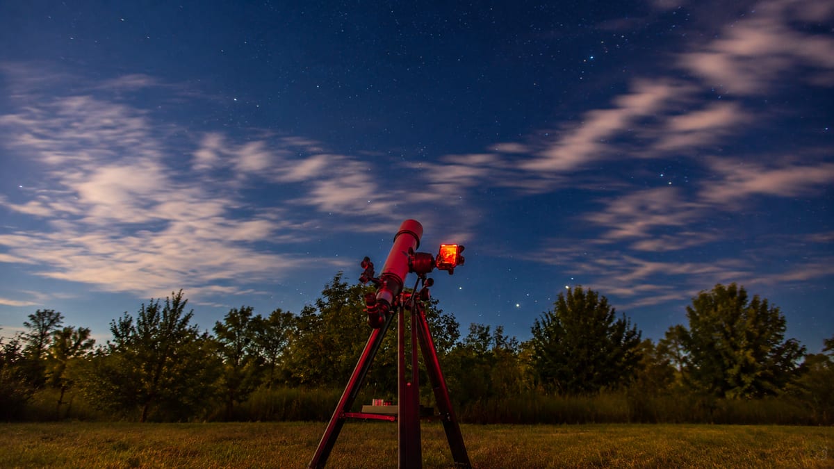 Ciel étoilé de nuit au-dessus des arbres, lunette pointée vers les astres